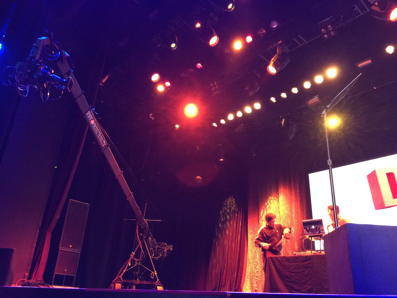 Camera crane covering a concert performance under stage lighting